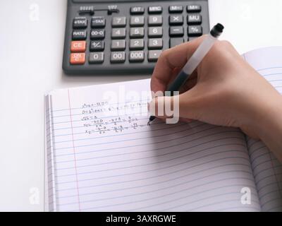 A student doing math in a notebook. Close up. Stock Photo