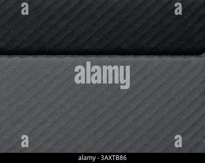 Close-up view of textured fabric in dark gray and light gray tones, highlighting unique ribbed pattern. Stock Photo