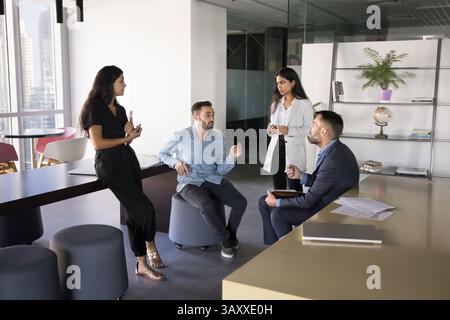 Group of four diverse professionals engaged in informal discussion Stock Photo