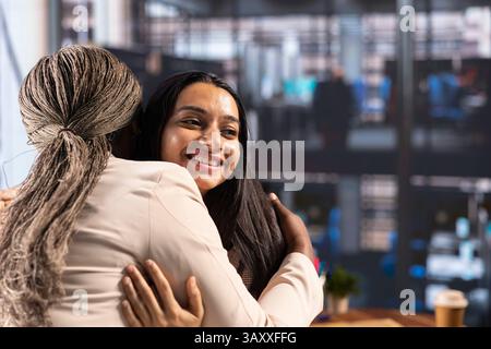 Powerful satisfied entrepreneurs hugging and congratulating each other after hard work and dedication, achieving great things together in a men dominated business industry, success story. Stock Photo