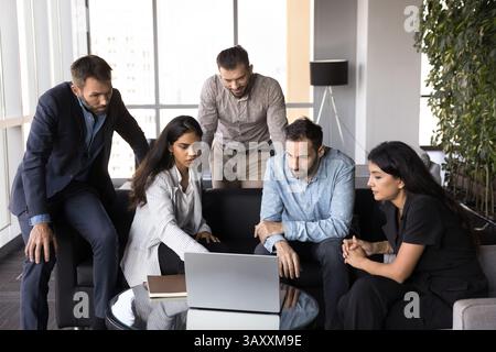 Multiethnic teammates discussing online presentation using laptop Stock Photo