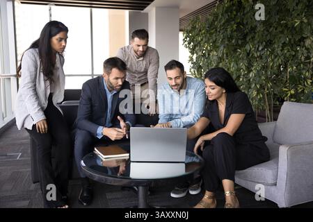 Workflow using modern technology of five diverse employees Stock Photo