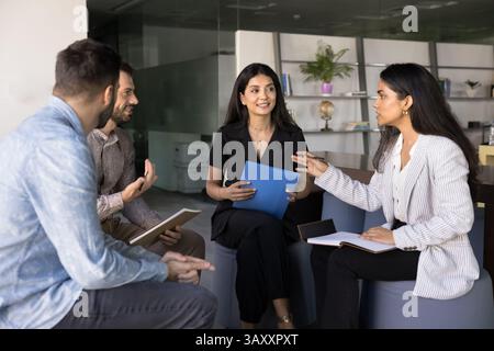 Briefing participant engaging in collaborative discussion with teammates Stock Photo