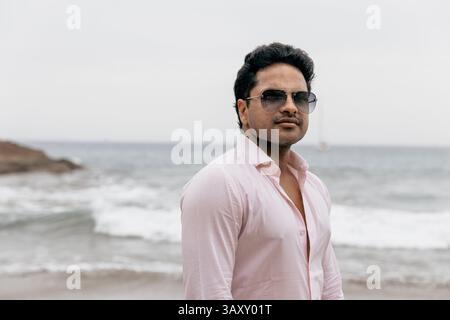 Portrait of an attractive successful Indian man on the beach during vacation. Stock Photo