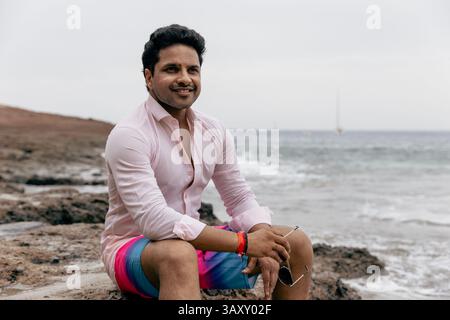 A confident man at the beach relaxing during his summer holiday Stock Photo