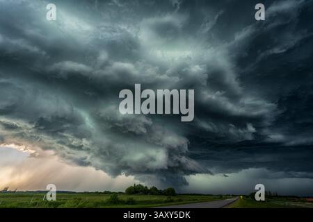 Ominous summer storm clouds pass over a prairie highway Stock Photo