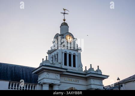 The Saffron Walden library's clock tower stands tall against a twilight sky, displaying the time. Stock Photo