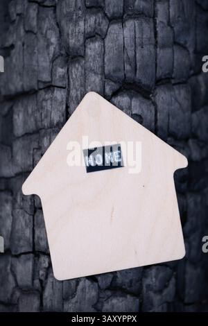 Wooden house on bark burnt tree with inscription home Stock Photo