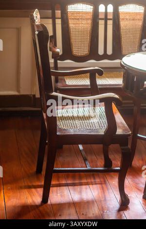 Traditional wooden chair inside an old Filipino mansion in Metro Manila, Philippines, showcasing classic craftsmanship and heritage interior design Stock Photo