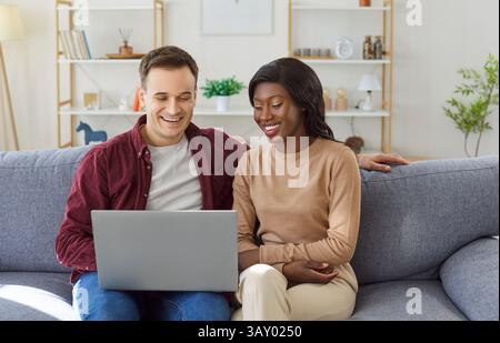 Couple Laughing With Laptop At Home Stock Photo