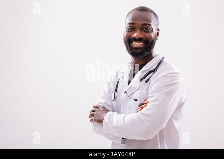 Confident black male healthcare worker in medical uniform smiling and looking at camera,, portrait on gray background.. Stock Photo