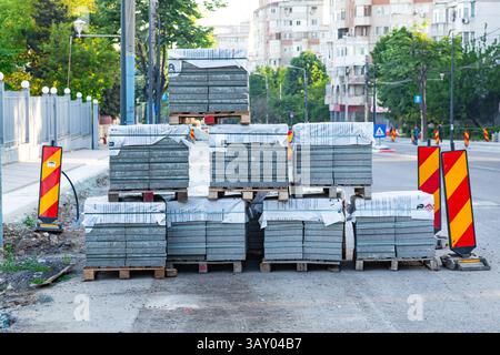 Packs of new paving granite tiles stacked on pallets for laying on the road. Stock Photo