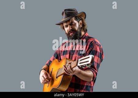 Country guitarist. Male in cowboys hat plays guitar the singer sings. Cowboy playing guitar, singer, sing. Man cowboys playing acoustic guitars in Stock Photo