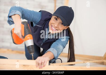 female carpenter using electric drill Stock Photo