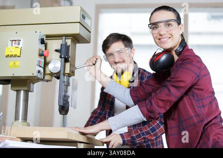 engineer training female apprentice to use cnc machine in factory Stock Photo