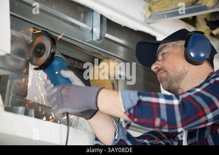 sparks flying as builder uses angle grinder Stock Photo