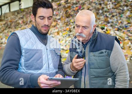 workers looking at digital tablet in recycling center Stock Photo