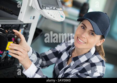 a happy woman fixing the printer Stock Photo