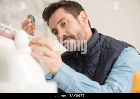 orker installing window curtain rod on the wall Stock Photo