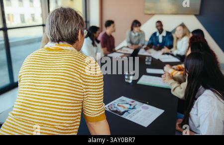 A lively university class in a city environment, where students are actively participating in a collaborative learning session around a round table. Stock Photo