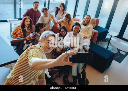 A group of university classmates posing together for a cheerful selfie, showcasing diversity, camaraderie, and inclusive community in a bright and mod Stock Photo
