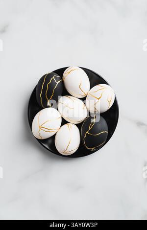 Stylish easter eggs decorated golden metal on marble table. Flat lay, top view. Happy Easter concept. Stock Photo