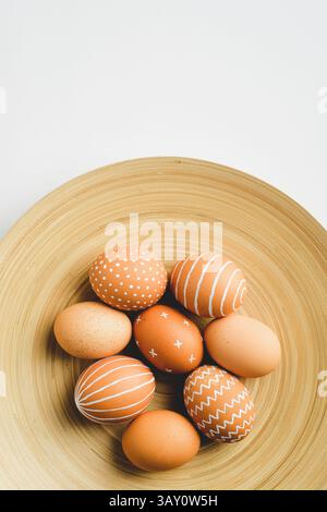 Simple Easter eggs on elegant plate on white background. Happy Easter concept. Stock Photo