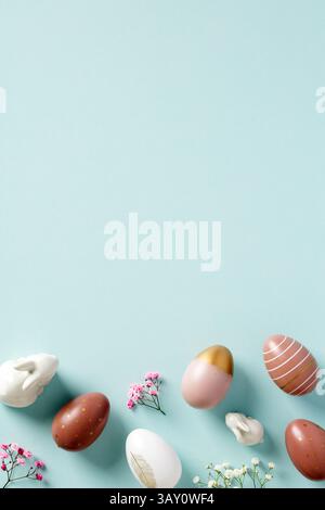 Happy Easter poster template with space for text. Colorful Easter eggs, decorative bunnies, flowers on light blue background Stock Photo