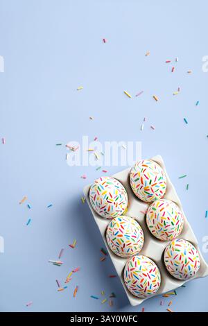 Colorful Easter eggs on pastel blue background. Creative design, flat lay, top view. Stock Photo