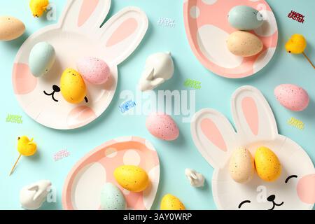 Happy Easter concept. Easter table with plates, colorful eggs and decorations on blue background. Stock Photo