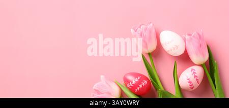Happy Easter banner design. Colorful Easter eggs and tulips on pink background. Stock Photo