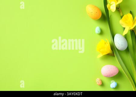 Happy Easter concept. Easter banner template with colorful Easter eggs, yellow spring flowers on green background. Stock Photo