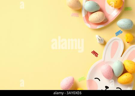 Happy Easter banner design with colorful Easter eggs and tableware on yellow background Stock Photo