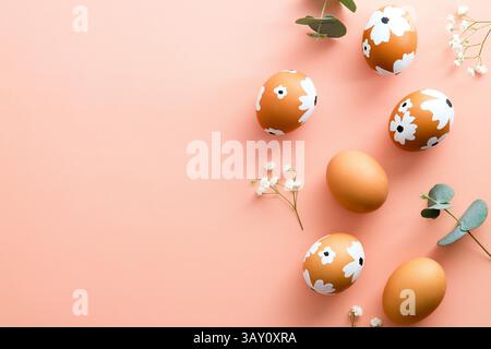 Elegant Easter flat lay composition. Colorful Easter eggs and flowers on pastel pink table. Happy Easter concept. Minimal style. Stock Photo