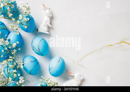 Natural Easter Eggs with flowers and rabbits decorations on marble background. Stock Photo