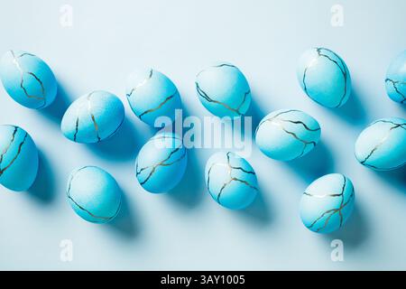 Blue Easter eggs painted marble texture on light blue background. Flat lay, top view. Stock Photo