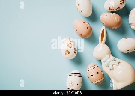 Happy Easter concept. Beautiful floral painted Easter eggs and ceramic bunny on pastel blue background. Stock Photo