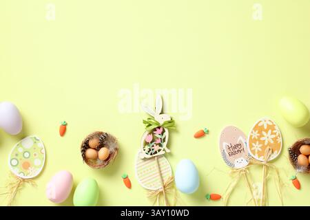Happy Easter card. Flat lay Easter eggs, decorations, nest with eggs on green background. Top view. Stock Photo