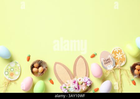 Happy Easter banner, poster, greeting card template. Flat lay composition with Easter bunny ears, wooden eggs decoration, colorful eggs, carrot on lig Stock Photo