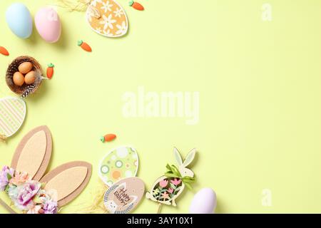 Happy Easter flat lay composition. Top view rabbit bunny ears, Easter eggs, wooden decorations on pastel green background. Stock Photo