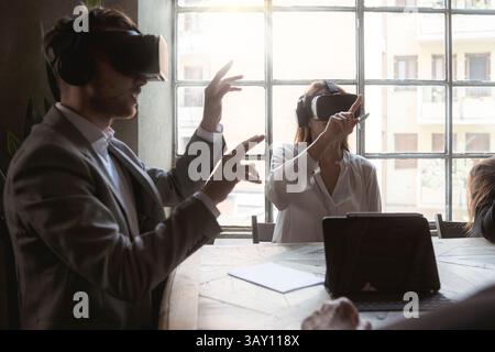 Professional team testing VR headsets during a meeting in modern office. Technology and innovation in business collaboration. Stock Photo