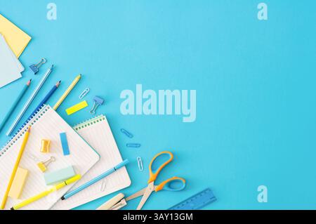 Back to school concept, school supplies and accessories on blue background, notebook, pencils, student scissors, paperclip, duster, flat lay Stock Photo
