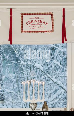 Christmas curtain and snow outside the window. Advent lights. Stock Photo