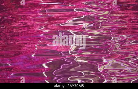 Stunning pop art surreal magenta colored water surface in the sunlight Stock Photo