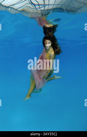 October 15, 2014 - Odessa, pool, Ukraine - Young beautiful woman with long hair in a bright dress under water, underwater fashion in the pool, Odessa, Ukraine (Credit Image: © Andrey Nekrasov/ZUMA Wire/ZUMAPRESS.com) Stock Photo