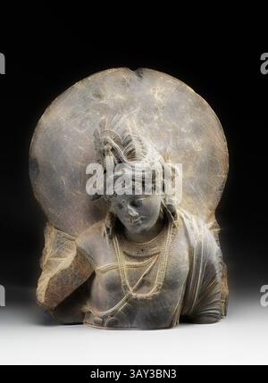 A carved stone sculpture depicting a serene figure with intricate detailing, adorned with jewelry and a headdress, set against a softly illuminated backdrop. The figure exudes a sense of tranquility and grace, with a finely textured surface showcasing skillful artistry., Unknown (Gandharan), Bodhisattva, between 200 and 400, Gray schist, Overall: 20 1/2 × 16 1/2 × 7 3/4 inches (52.1 × 41.9 × 19.7 cm), Classic art with a modern twist reimagined by Artotop Stock Photo