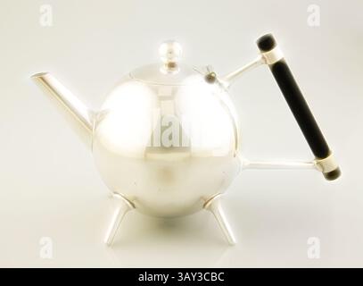 A sleek, modern teapot with a rounded body, slender spout, and a black handle, resting on four sturdy legs. Its polished surface reflects light, adding an elegant touch to the design., Christopher Dresser, English, 1834-1904, Teapot, ca. 1880, silver plate and ebony, Overall: 5 1/2 × 8 3/4 × 4 1/4 inches (14 × 22.2 × 10.8 cm), Classic art with a modern twist reimagined by Artotop Stock Photo