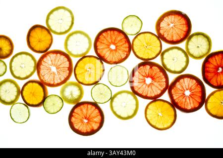 A colorful array of citrus slices, including oranges, lemons, limes, and grapefruits, displayed on a bright background. The vibrant colors create a fr Stock Photo