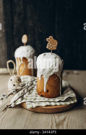 Traditional Russian Easter kulich breads, generously frosted with white icing and adorned with charming Easter themed gingerbread cookies and willow c Stock Photo