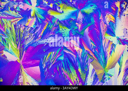 A vibrant microcrystals under the microscope, featuring a brilliant array of colors including blues, purples, greens, yellows, and pinks. The intricat Stock Photo